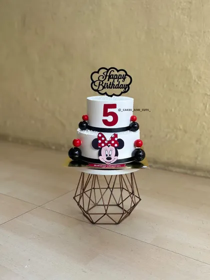 A fun Minnie Mouse cake for a fifth birthday. The two-tier design in classic red, black, and white is a timeless choice for Disney fans.
