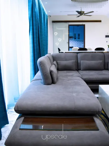 We call this living space "The Hall of Play." We kept the design minimal to respect the white space, using a large sectional sofa and bright blue curtains to add comfort and a pop of color.