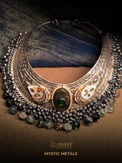 A magnificent oxidized silver collar necklace, or hasli, featuring a large central stone and a fringe of smaller beads. A true statement of power and style.