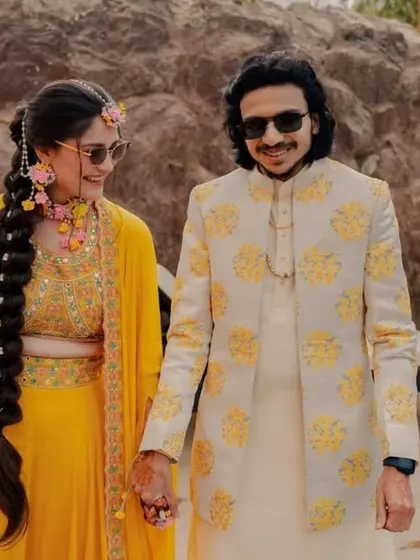 A beautiful portrait of Atul and Yashika walking by the pool at their Haldi ceremony. Their coordinated yellow outfits and happy smiles perfectly match the sunny, joyful vibe of the day.
