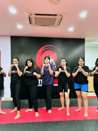 A group of women from our academy stands together in a fighting stance. This image captures the strength, solidarity, and spirit of the female members of the StrikeHive community.