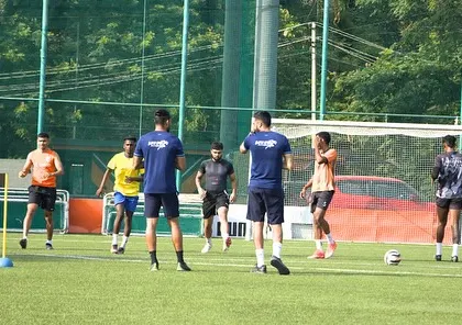 My coaches observing and guiding athletes through an agility drill using cones and markers. This demonstrates our attention to detail in refining movement patterns for better on-field performance.