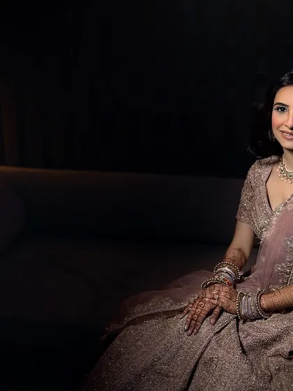 A serene portrait of the bride seated on a couch. The soft, ambient lighting creates a calm and peaceful mood.