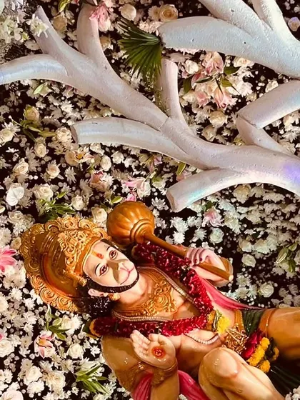 An idol of Lord Hanuman placed within the elaborate floral arrangement. We ensure all deities are integrated thoughtfully into the overall design.