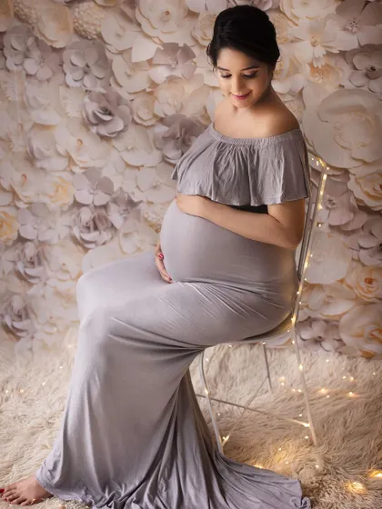 A peaceful and elegant pose. Seated on a simple chair with fairy lights, this shot combines classic portraiture with a touch of modern whimsy.