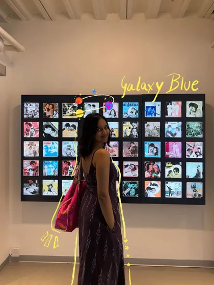 Galaxy blue. A photo in front of a wall of old movie posters, with a space-themed doodle.