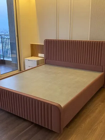 We would keep our alarm clock off on this bed. This custom upholstered bed in a soft pink is the centerpiece of a serene bedroom, proving that comfort and high style can definitely coexist.