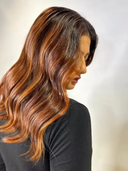 This warm, coppery red balayage is perfect for making a statement. The color is rich and vibrant, and the soft waves help to showcase the beautiful blend of tones.