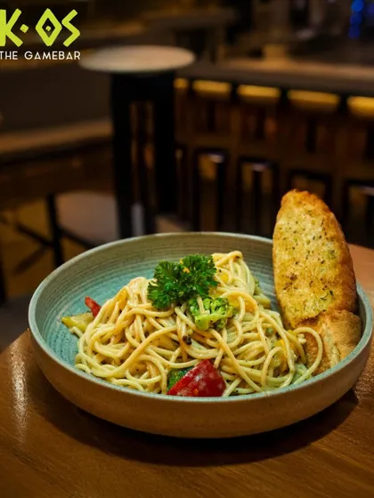 Twirl it, taste it, and enjoy. A classic bowl of spaghetti aglio e olio, served with a side of crispy garlic bread.