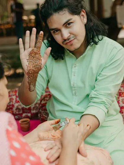 A guest gets his Mehendi done, showing how this beautiful tradition can be enjoyed by everyone at the wedding.