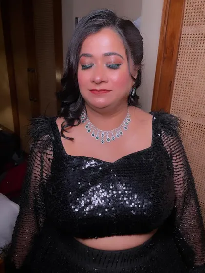 A close-up of the eye makeup, featuring a touch of green glitter to add a pop of color to the all-black ensemble.