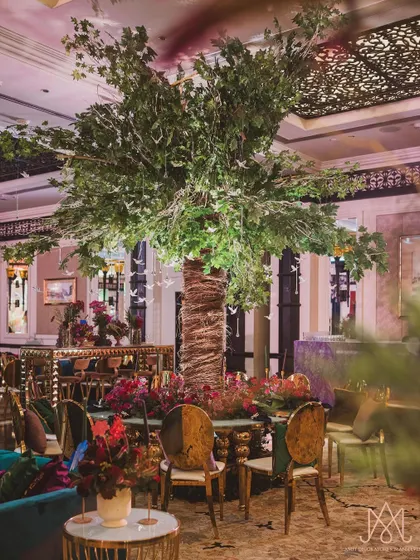 Another angle of the magnificent indoor tree installation, showing how it serves as a central anchor for the seating arrangement and overall decor.
