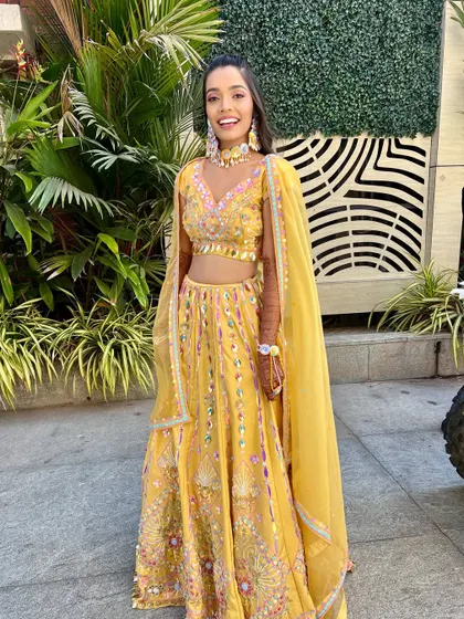 A full-length shot of the bride, looking radiant and joyful in her yellow ensemble.