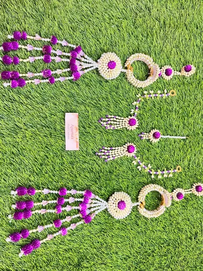 Another view of the purple and white Mehendi jewellery set, laid out on a banana leaf to highlight the fresh materials.