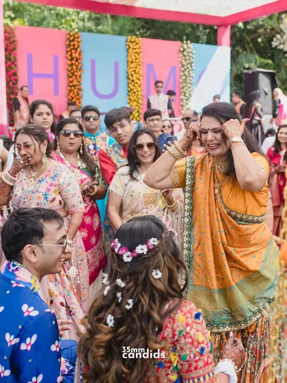 A mother or aunt dancing with joy, blessing the couple during a pre-wedding celebration. These are the heartwarming family moments that make a wedding special.