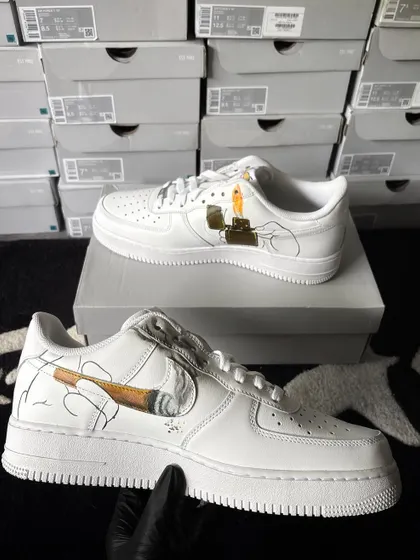 The other shoe in the pair, featuring a hand holding a lit joint that forms the swoosh.