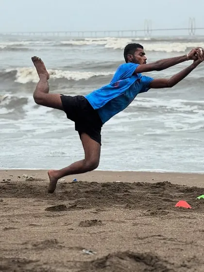 A player mid-flight, taking a spectacular diving catch on the sand. This image captures the athleticism and commitment we foster.