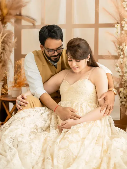 A sweet shot of a couple looking down at the baby bump together, a moment full of shared anticipation.