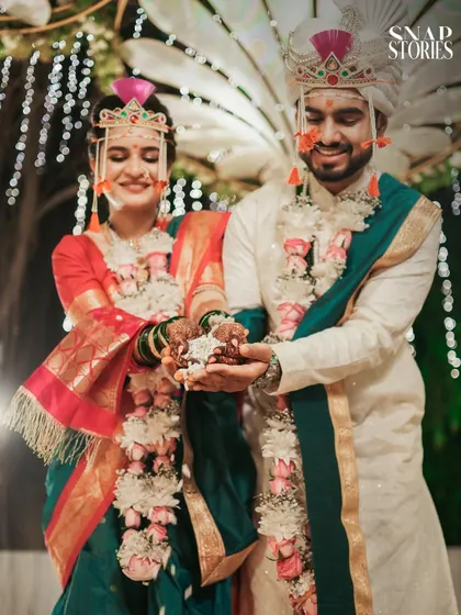 The couple holds puffed rice for the Laja Homa ritual, a key part of the Hindu wedding ceremony. We document these significant traditions with reverence and artistry.