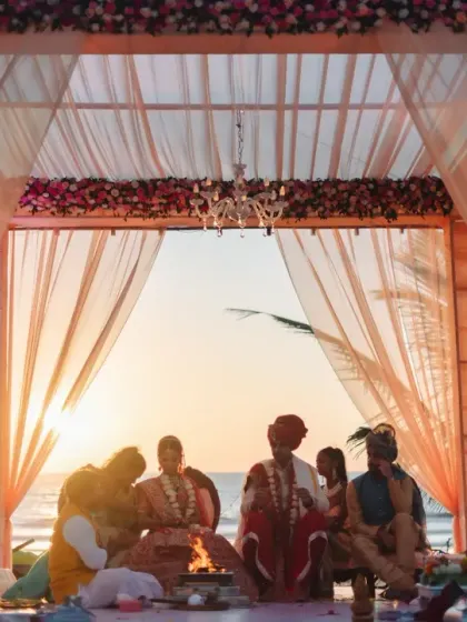 A breathtaking view of the sunset wedding ceremony on a Goa beach. The couple is silhouetted against the golden sun, creating a truly magical and romantic frame.