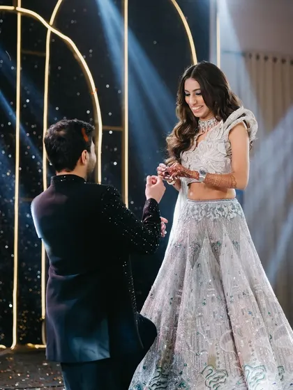 A romantic moment during the Sangeet, with the groom proposing. Her makeup is designed to look beautiful in these emotional, candid shots.