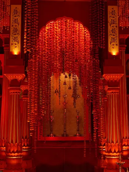 Another angle of the mandap, highlighting the hand-painted shola flowers and brass bells hanging from the ceiling.