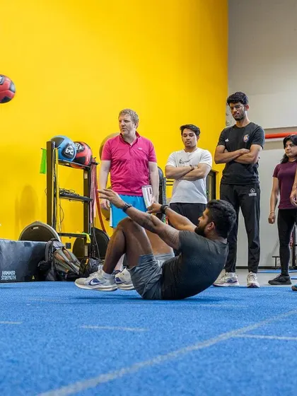A participant practices an explosive core exercise with a medicine ball during a practical session on core and rotational strength.