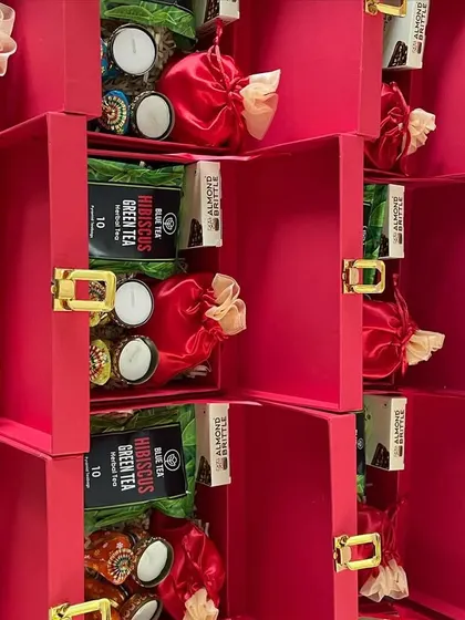 A glimpse of our red suitcase hampers being prepared for a large order. Each box is carefully filled and checked before being sent out.