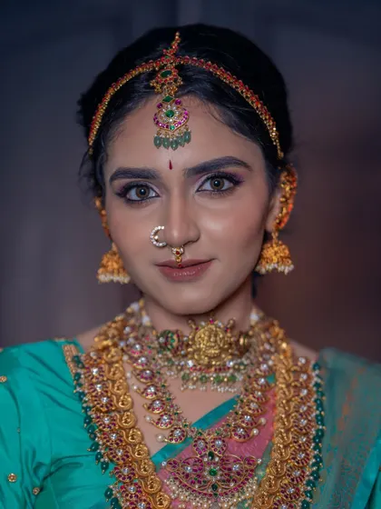 The beauty is in the details. This close-up shows our intricate temple jewellery, including the choker, layered haram, and matha patti, all available to create your perfect bridal look.