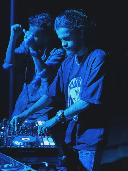 A cool, blue-toned image of me and a crew member behind the decks.