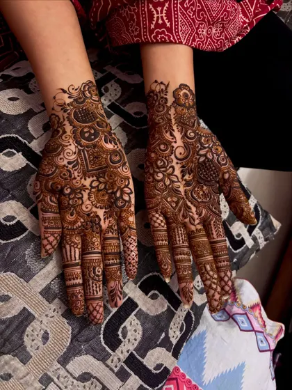 A dense and intricate non bridal design that covers the entire back of the hand. The mix of patterns creates a rich and textured look.