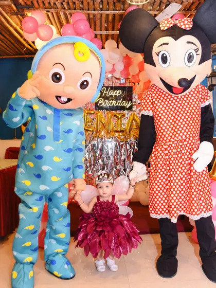The birthday princess holding hands with her favorite cartoon characters. These moments make a party unforgettable.