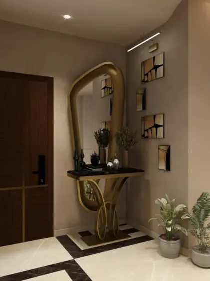 The entrance features a stunning console table with a sculptural gold base and a large, uniquely shaped mirror.