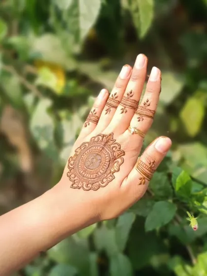 A simple and elegant Arabic design featuring a mandala on the back of the hand with minimal finger details.