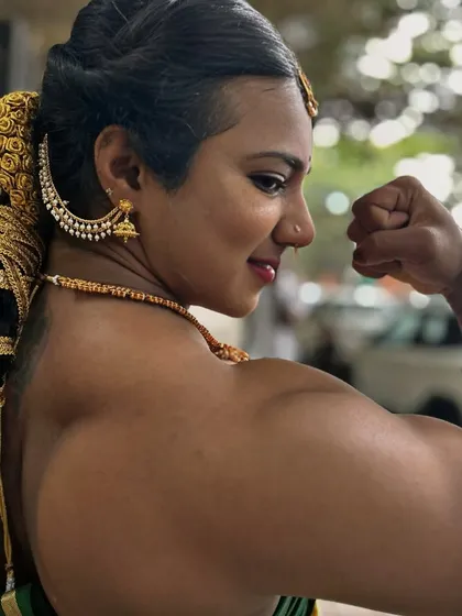 A close up profile shot, focusing on the bicep peak and the intricate details of my traditional hairstyle and earrings. Every detail contributes to the overall story of strength.