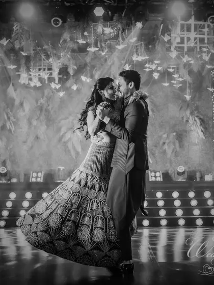 A timeless black and white shot of the couple's first dance, capturing the romance and elegance of the moment under a ceiling of hanging butterflies.