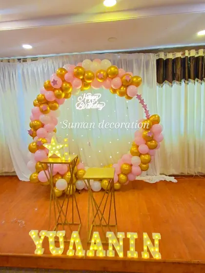 A full view of the pink and gold stage decoration, showing the 'Happy Birthday' neon sign and light-up star prop.