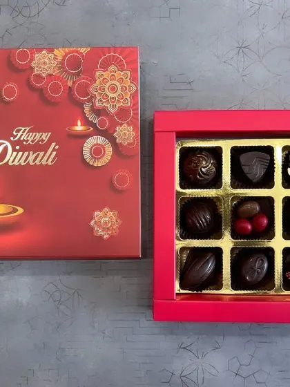 An elegant "Happy Diwali" chocolate box with a classic red and gold design. Inside, you'll find a selection of nine assorted premium chocolates, perfect for sophisticated corporate gifting.