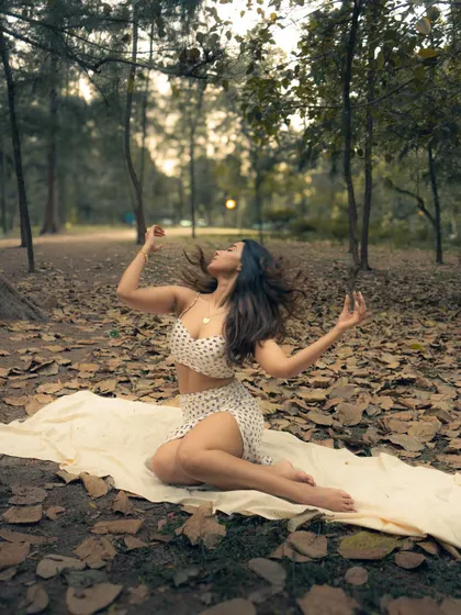 A full-length portrait capturing a moment of freedom and expression. Using a simple cloth on the ground, we created a clean space to focus on the subject's pose amidst the natural texture of the forest floor.