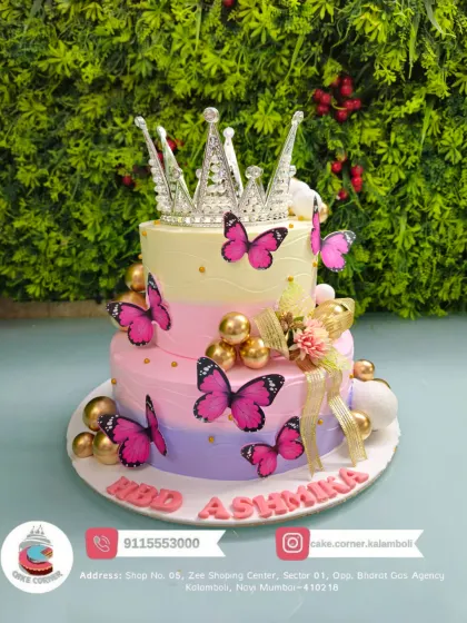 A grand two-tier butterfly and crown cake in pastel rainbow colours. The large silver crown and pink butterflies make it a truly royal and magical centerpiece.
