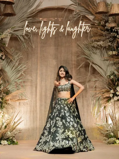 The bride posing in front of the stunning bohemian Sangeet backdrop. The neon sign "love, lights & laughter" perfectly captures the spirit of the evening.