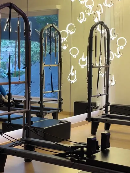 The details matter. From the modern chandeliers to the sleek black reformers, every element is chosen to create an elevated workout experience.