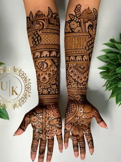 This full-hand bridal design is rich with traditional Rajasthani motifs, including peacocks, elephants, and the couple's initials 'JD' hidden within the pattern.