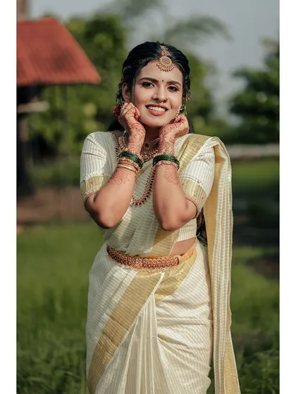 A happy and confident portrait of the bride, her hands framing her face.