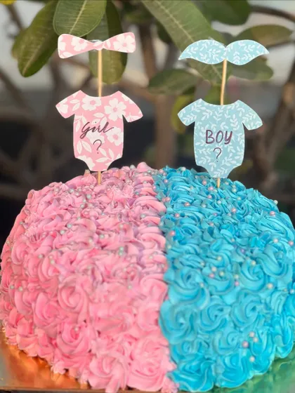 He or she? What will it be? This half-and-half gender reveal cake is a fun and delicious way to share your big news, with pink and blue rosette piping keeping the secret until the first slice.