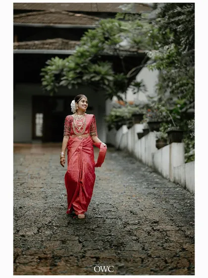 A full-length shot of the bride walking gracefully in her beautiful pink saree.