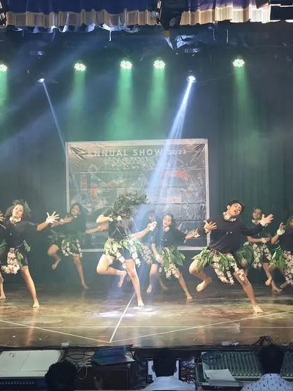 The full tribal group in motion, filling the stage with energy and raw power.