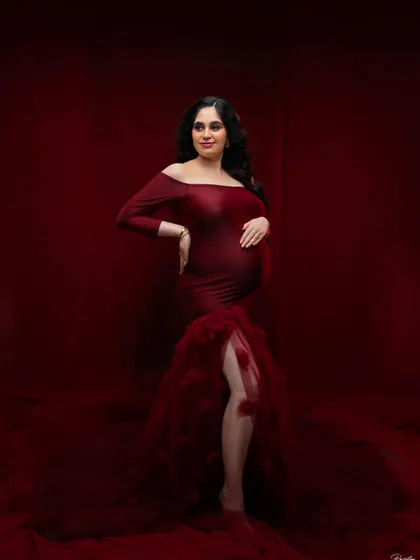 A full-length portrait showcasing a magnificent off-the-shoulder red gown. The rich color and mermaid-style tulle train create a classic, high-impact look that is both elegant and unforgettable.