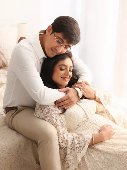 A sweet and tender moment. The gentle way he embraces her from behind shows his love and protection as they cherish this special time.