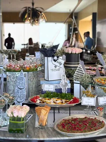 A stylish and modern grazing table for a house party, featuring Parisian-themed decor. The spread includes a variety of appetizers, dips, and desserts, demonstrating how we tailor our setups to match any party theme.